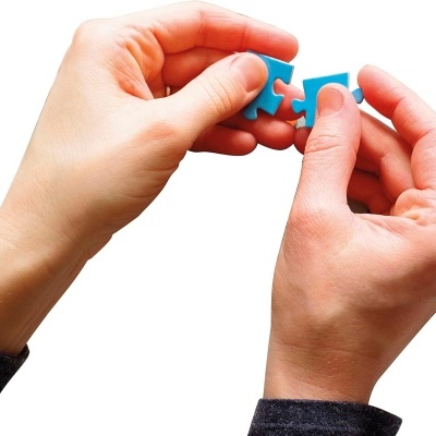Duas mãos segurando peças de puzzle azul