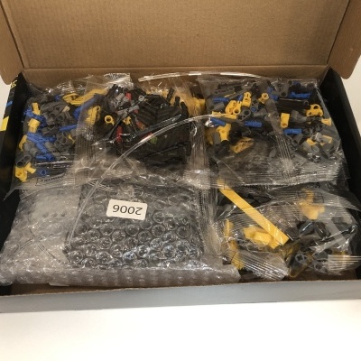 Caixa com sacos plásticos contendo peças pequenas coloridas para montagem