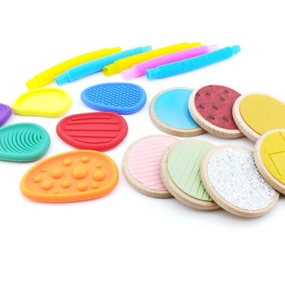 Conjunto de brinquedos coloridos de madeira e plástico em várias formas e texturas