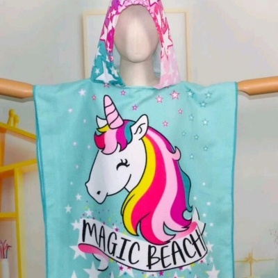Poncho infantil com estampa de unicórnio colorido e texto 'MAGIC BEACH'