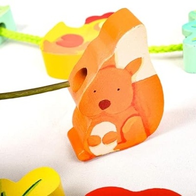 Cordão infantil com contas de madeira coloridas em formas como esquilo e folhas