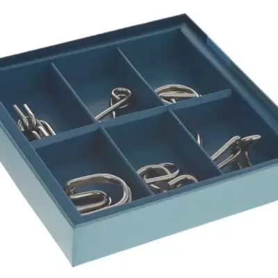Organizador azul com puzzles metálicos prateados em compartimentos.