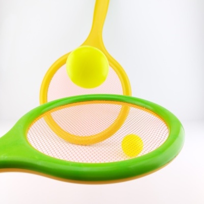Raquetes plásticas verde e amarela com bolas amarelas e rede cor-de-rosa
