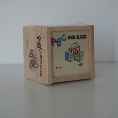 Caixa de blocos de madeira com letras ABC coloridas e desenhos de blocos
