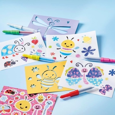 Cartões coloridos com desenhos de insetos e flores, canetas coloridas e moldes de plástico roxo e amarelo para pintar.