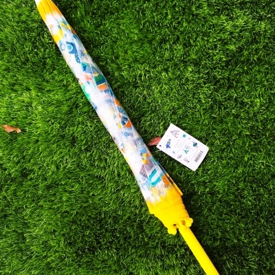 Guarda-chuva fechado amarelo com padrão colorido sobre relva verde