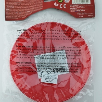 Disco voador vermelho em embalagem transparente com cartão vermelho e texto multilíngue