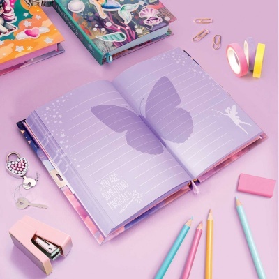 Caderno lilás aberto com borboleta e fada, lápis de cor e acessórios rosa e amarelos