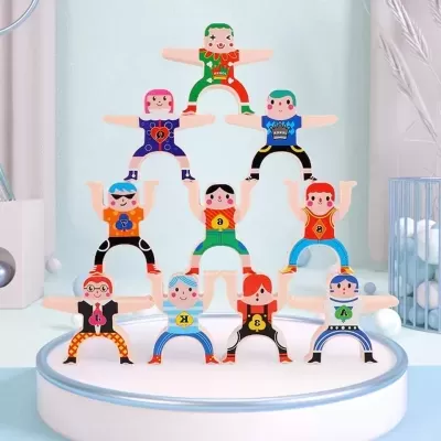 Bonecos de madeira coloridos empilhados em pirâmide numa plataforma redonda branca