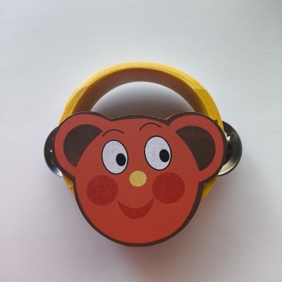 Pandero infantil com rosto de urso desenhado, caixa amarela e pratos metálicos