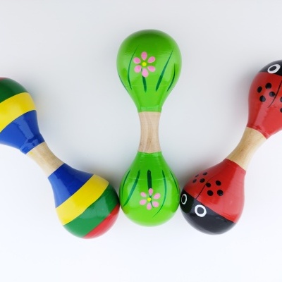 Três maracas coloridas de madeira com cabo natural