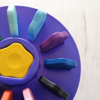 Brinquedo colorido com base roxa e peças destacáveis multicoloridas