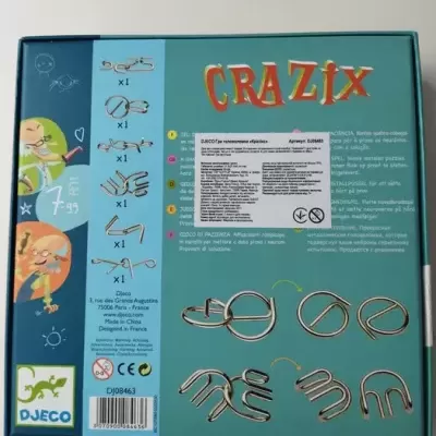 Parte de trás da caixa do jogo CRAZIX com instruções e imagens dos 7 puzzles metálicos incluídos