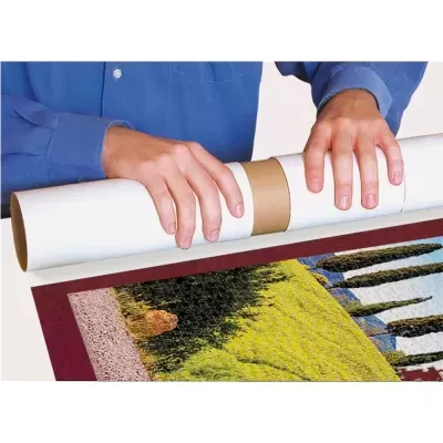 Mãos segurando tubo de papel branco sobre puzzle de paisagem verde com árvores