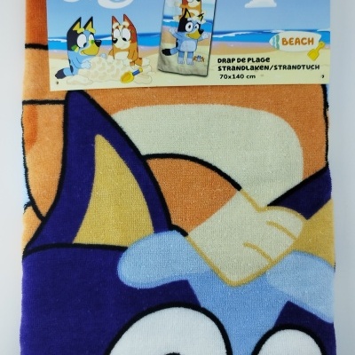 Toalha de praia Bluey azul e laranja com personagem e embalagem com texto