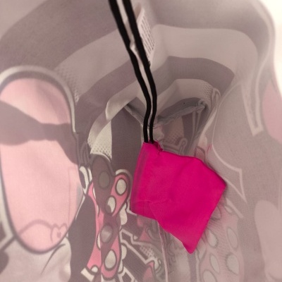 Interior de mala com padrão gráfico e bolsa pequena rosa pendurada