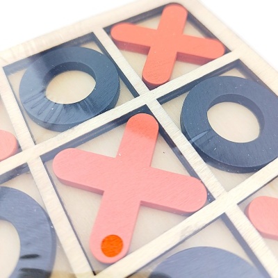 Jogo da velha em madeira com peças X cor-de-rosa e O pretas numa caixa transparente