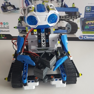 Robô educativo azul, branco e preto com olhos grandes azuis e rodas de lagarta pretas