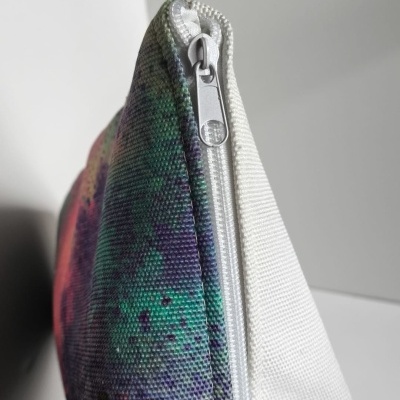 Bolsa colorida com fecho branco e padrão abstrato