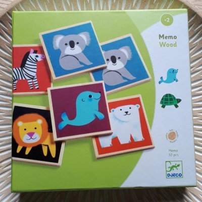 Caixa de jogo infantil Memo Wood com imagens de animais coloridos sobre uma superfície redonda texturizada