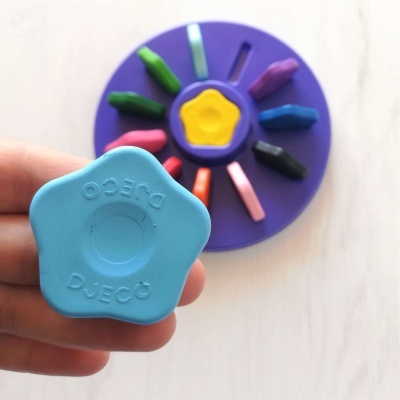 Peça azul de plástico com palavra DJECO, suporte roxo com pedaços coloridos