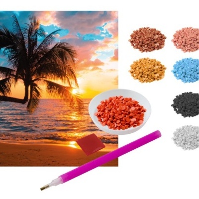 Peças coloridas para artesanato e caneta rosa junto a imagem de praia ao pôr do sol