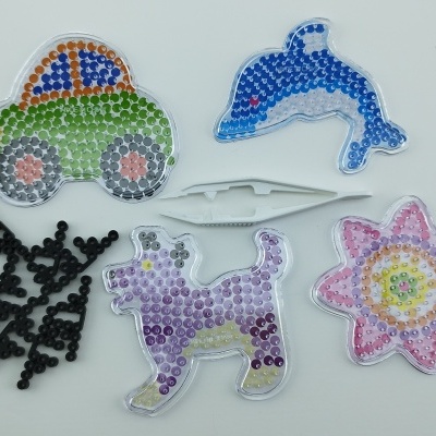 brinquedos coloridos em forma de carro, golfinho, cão, flor e galho com textura de contas