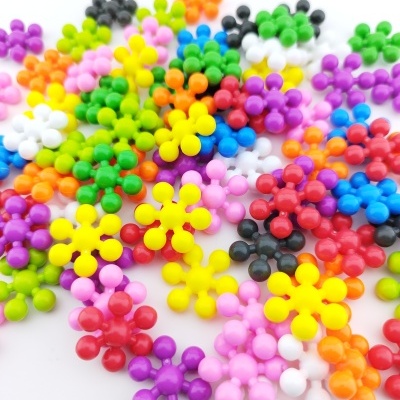 Peças de plástico em forma de flores coloridas sobre fundo branco