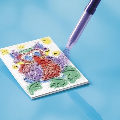 Placa com coruja em relevo sendo pintada com aplicador de tinta roxa