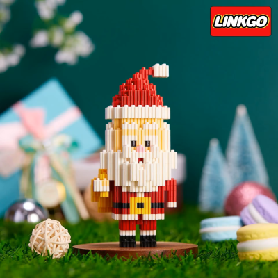 Figura de blocos representando Pai Natal com chapéu vermelho e barba branca em suporte de madeira