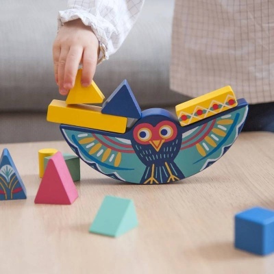 Brinquedo de coruja colorida de madeira com blocos geométricos coloridos numa mesa