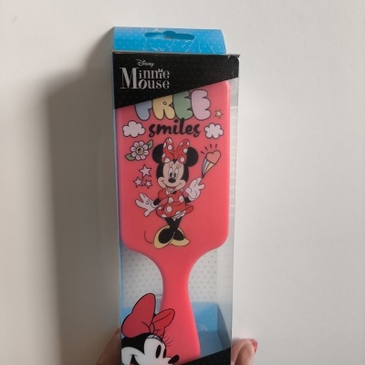 Escova de cabelo rosa com Minnie Mouse e texto em embalagem transparente.