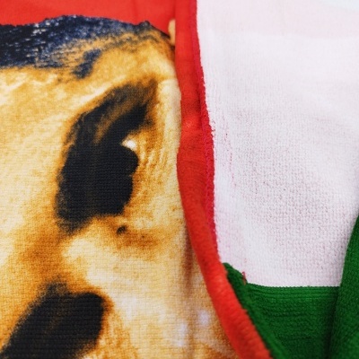 Toalha com estampa de cão e borda vermelha, lado frontal e verso visíveis