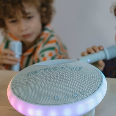 Coluna portátil KIDWOLF cinzenta com luzes LED e crianças a cantar com microfones