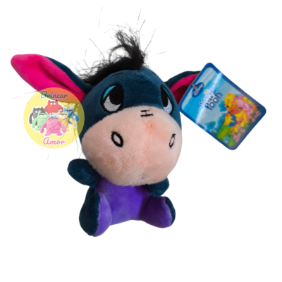 Pelúcia azul e roxa de Bisonho com etiqueta azul pendurada