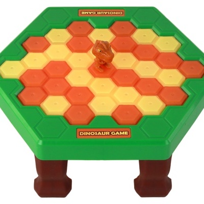 Jogo de tabuleiro verde com peças amarelas e laranjas e dinossauro de brinquedo