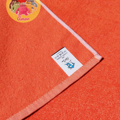 Toalha laranja com etiqueta de instruções de lavagem