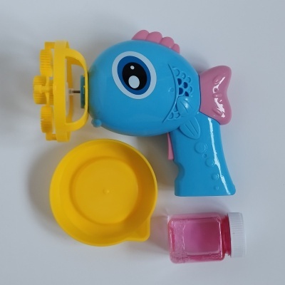 Brinquedo de bolhas de sabão azul em forma de peixe com bacia amarela e frasco pequeno rosa