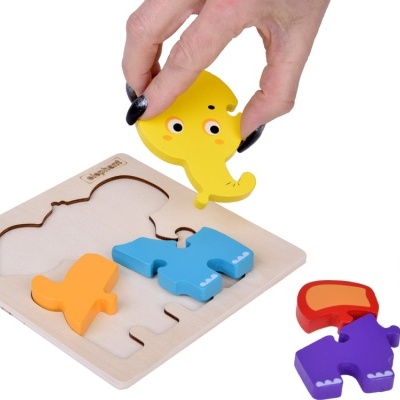 Quebra-cabeça de figuras de elefante coloridas em madeira com mão segurando peça amarela