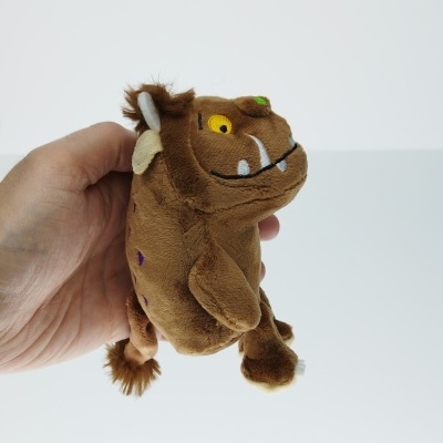 Pelucho castanho de animal fictício com olhos amarelos e dentes brancos