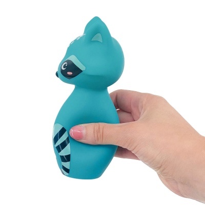 Brinquedo azul em forma de guaxinim segurado por uma mão