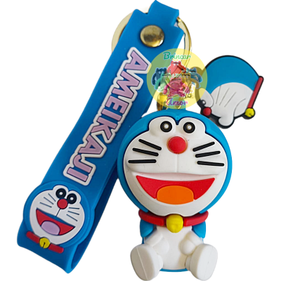 Chaveiro de borracha do personagem Doraemon e tira azul com texto AMERKAJU