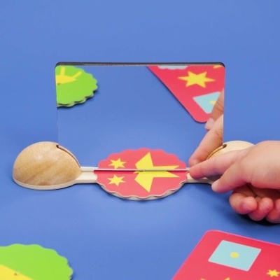 espelho quadrado com moldura preta e objetos coloridos em fundo azul