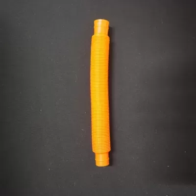 Peça cilíndrica plástica laranja com textura central sobre fundo preto