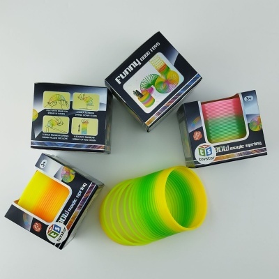 Três caixas de mola espiral de brinquedo colorida e uma mola amarela e verde fora da embalagem