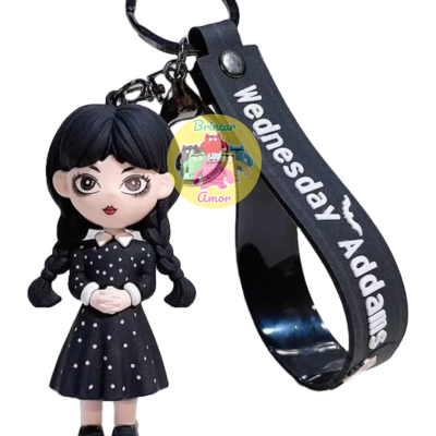 Porta-chaves com boneca de Wednesday Addams em vestido preto de pontos brancos e fita preta com texto branco