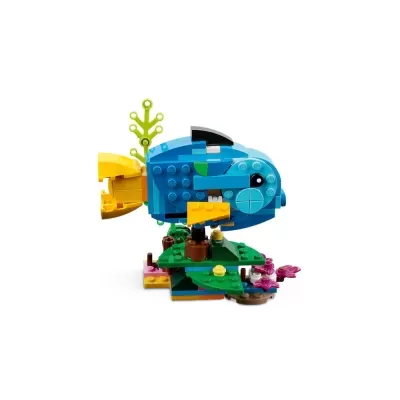 Peixe azul e amarelo de peças LEGO sobre base decorada com planta e flores.