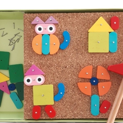 Jogo infantil de construção com peças de madeira coloridas e martelo em caixa.