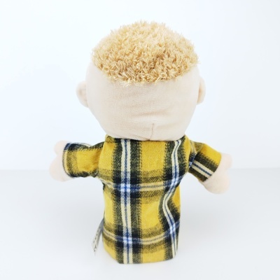Boneco de pelúcia visto de costas com cabelo encaracolado amarelo e camisa xadrez amarela.