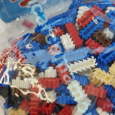 Peças plásticas coloridas para construção de personagem pixelado azul e branco na embalagem.